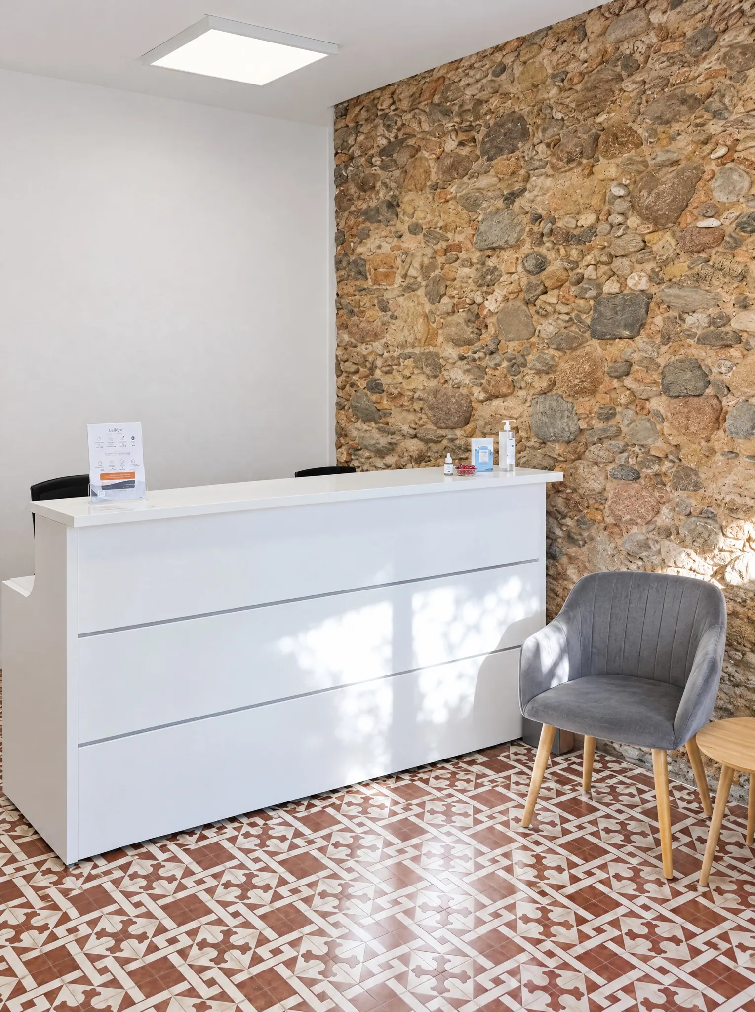 Recepción de Arulaser, con la pared de piedra original del local